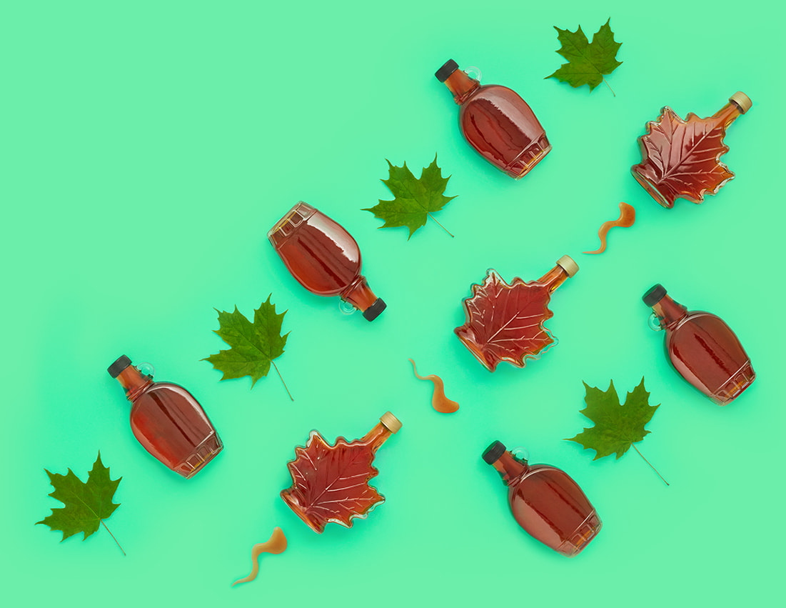 Green background with decorative glass maple syrup bottles arranged in a pattern with green maples leaves.